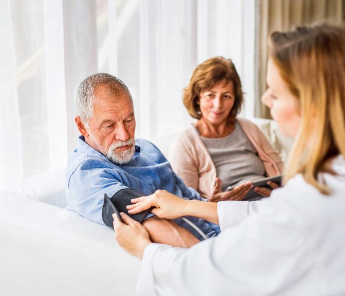 Un doctor măsoară tensiunea arterială a unui bărbat.
